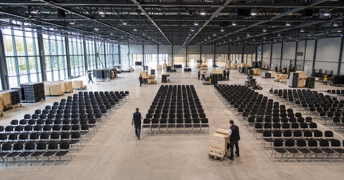 Messehalle beim Aufbau mit Stuhlreihen